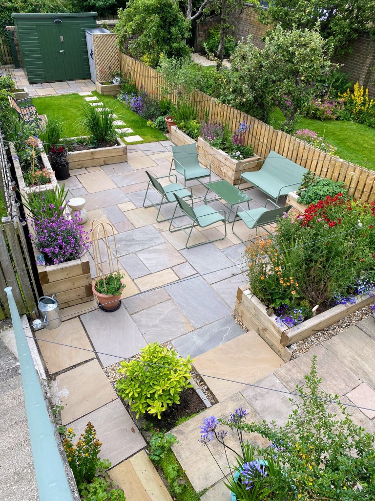 Edinburgh garden transformed with paved seating areas, raised planters, and vibrant flowers.